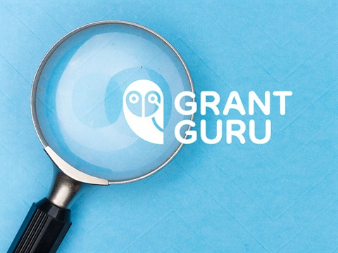 Grant guru logo overlapping a magnifying glass