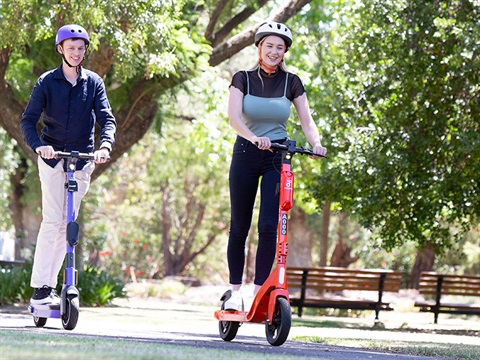 two-people-riding-e-scooters-on-pathway.jpg