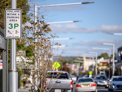 Three hour parking sign and cars along roadside