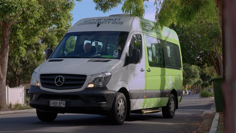 Green bus driving on street.jpg