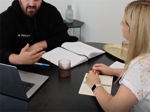 a woman advisor and a male business owner seated at a table during a mentorship meeting
