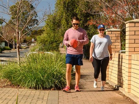 man and woman walking along footpath