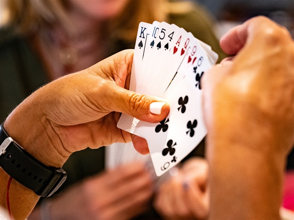Person playing Bridge holding cards