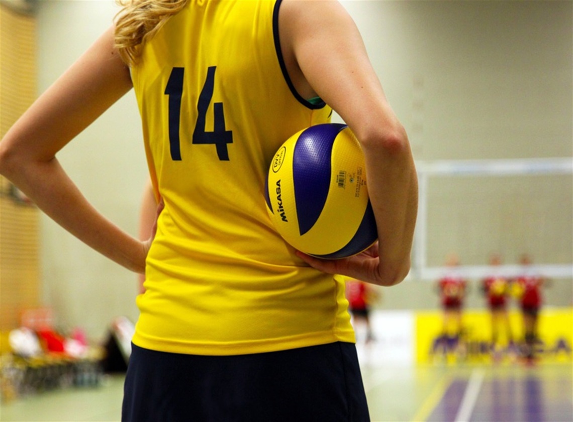 Volleyball player holding a ball on the sidelines