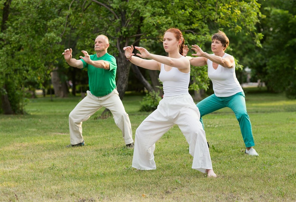 Group of three people engaging in Tai Chi meditation