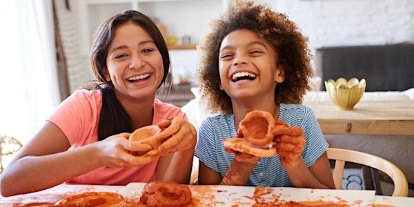 Two young people smiling with clay in their hands
