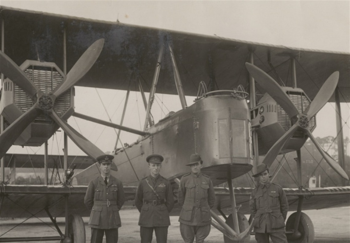 Three men in uniform standing in front of the Vickers Vimy airplane