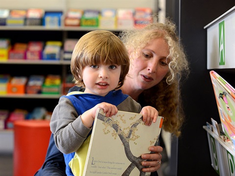 mum and young son selecting a picture book