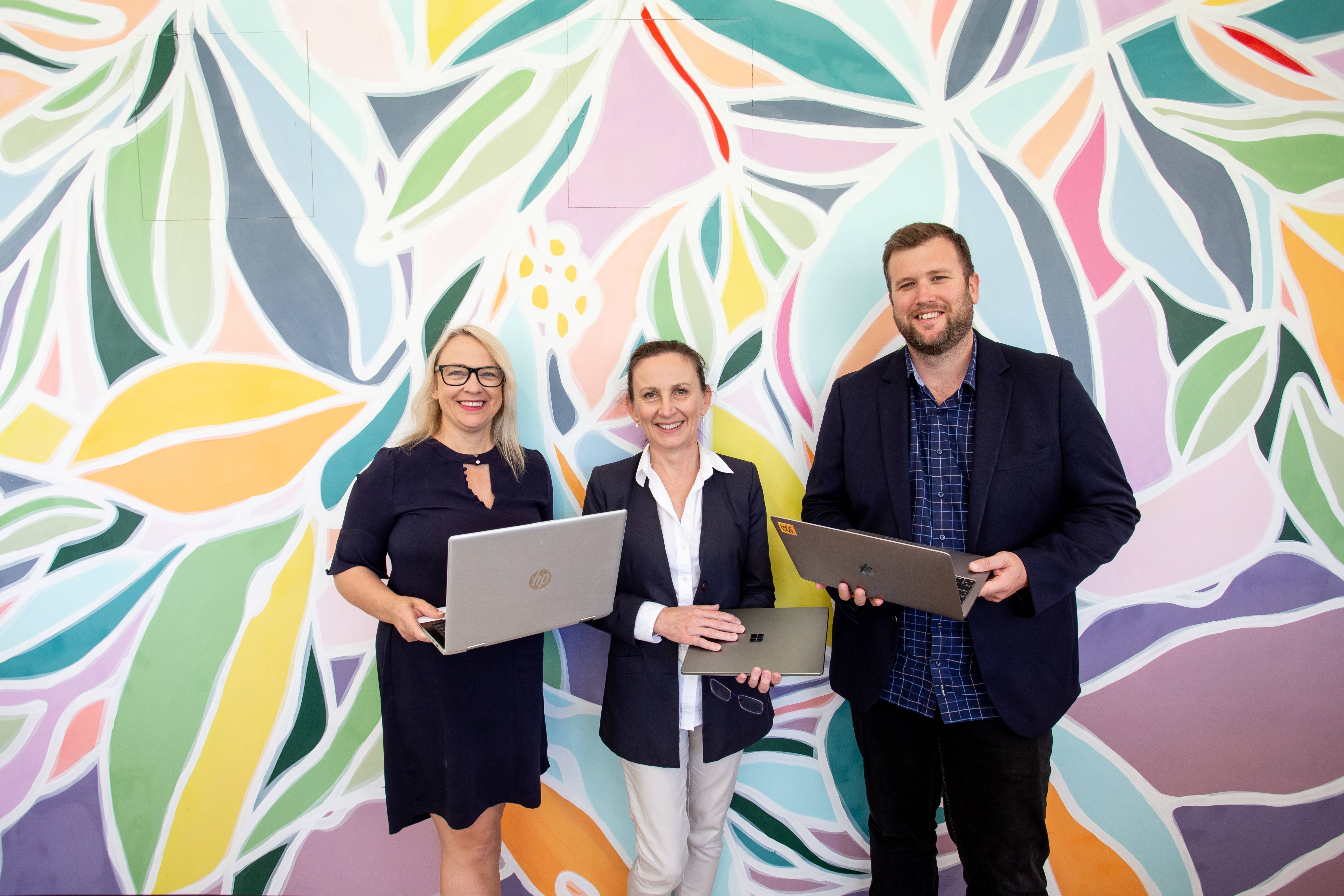 Local business operators in front of wall mural