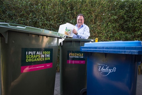 man placing recycling into yellow bin